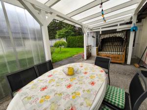 a table and chairs on a screened in porch with a table and a table at FeWo Renken in Trassenheide