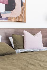 ein Bett mit zwei Kissen drauf mit in der Unterkunft Potts Villa Your Serene Beachside Escape in Pottsville