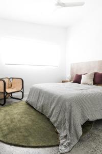 ein Schlafzimmer mit einem großen Bett mit einem grünen Teppich in der Unterkunft Potts Villa Your Serene Beachside Escape in Pottsville