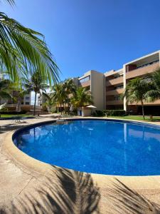 a large blue swimming pool in front of a building at Apartamento Exclusivo Av Principal LECHERIA in El Morro de Barcelona