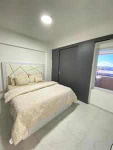 a bedroom with a white bed and a window at Apartamento Exclusivo Av Principal LECHERIA in El Morro de Barcelona