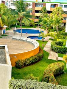 a park with a pool and palm trees and a building at Apartamento Exclusivo Av Principal LECHERIA in El Morro de Barcelona