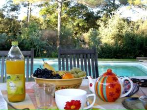 einen Tisch mit einer Schale Obst und einer Flasche Saft in der Unterkunft La Thébaïde in Saint-Marc-Jaumegarde