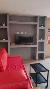 a living room with a red couch and a flat screen tv at Positiva 3 in Mar de Ajó