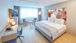 una camera d'albergo con letto, tavolo e sedie di Hotel Wettstein a Basilea