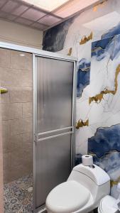 baño con aseo y pared con mural en casa tradicional completa, en Salento