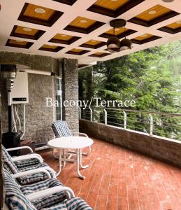 un patio con sedie e un tavolo su un balcone di Shahnoor cottages Luxury Apartment ad Abbottābād