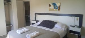 una camera da letto con un letto con due asciugamani sopra di ALTOS DEL MOLLE en VCP predio con solo 2 cabañas a Villa Carlos Paz