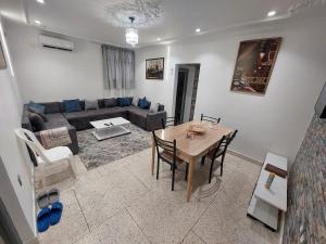 ein Wohnzimmer mit Tisch und Couch in der Unterkunft New feeling maison climatisée in Ville Nouvelle