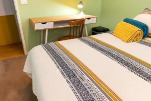 赫米特Rosewood Retreat的一间卧室配有一张带桌子和一张书桌的床。