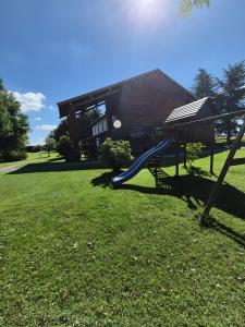 Cascina Brignolo - Casa Bianca في Morghengo: ملعب مع زحليقة ومظلة