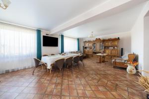 a large dining room with a table and chairs at Casa la Martin in Comarnic