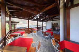 a restaurant with red tables and chairs and a couch at Casa la Martin in Comarnic