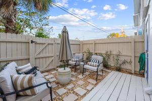 a patio with two chairs and an umbrella at Launch and Lounge Cozy Cape Canaveral Beach Townhome Near Surf and Space in Cape Canaveral