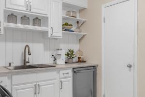 a kitchen with white cabinets and a sink at Launch and Lounge Cozy Cape Canaveral Beach Townhome Near Surf and Space in Cape Canaveral +19 photos