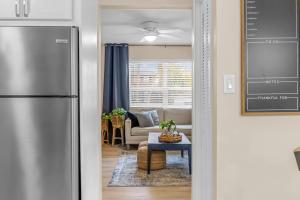 a kitchen with a refrigerator and a living room at Launch and Lounge Cozy Cape Canaveral Beach Townhome Near Surf and Space in Cape Canaveral