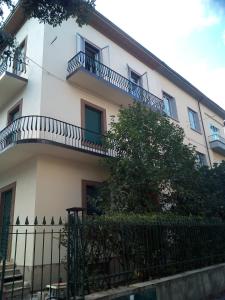 un edificio blanco con balcones y una valla en Villa Giove alla stazione - Prato, en Prato