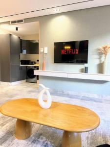 a wooden table in a living room with a tv at Appartement CFC in Casablanca