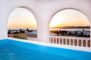 a villa with a swimming pool and a sunset at Crystal Dream Paros in Ekatondapilianí