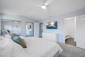 a white bedroom with a large bed and a desk at Stylish Townhome w Hot Tub 5 Min Walk to Beach in Cape Canaveral