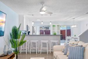 a living room with a couch and a kitchen at Stylish Townhome w Hot Tub 5 Min Walk to Beach in Cape Canaveral +38 photos