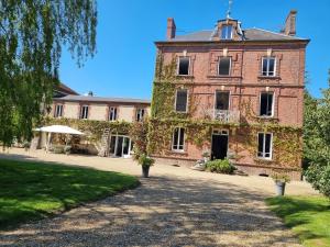 PrêtrevilleChambres à la campagne La Tuilerie的一座长着常春藤的大砖房