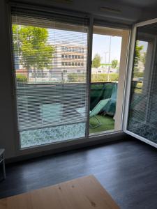 a room with two large windows with blinds on them at Square Walliser près ZENITH in Strasbourg