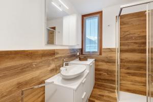 een badkamer met een witte wastafel en een spiegel bij Residenza Viola in Valdidentro +22 foto's