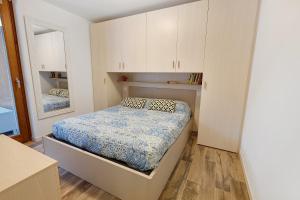 een kleine slaapkamer met een bed en een spiegel bij Residenza Viola in Valdidentro