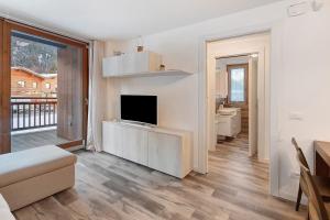 een woonkamer met een flatscreen-tv en een bank bij Residenza Viola in Valdidentro