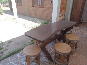un tavolo di legno e sgabelli accanto a un edificio di Los Jazmines depto a Cafayate