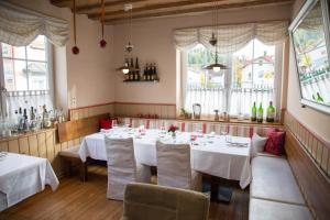 a restaurant with white tables and chairs and windows at Zum Blumentritt in Sankt Aegyd am Neuwalde