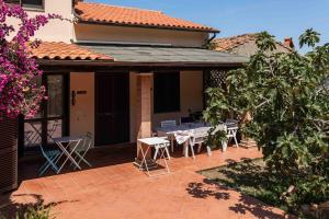 马尔恰纳Villa Shanti - Isola d'Elba的房子上带桌椅的露台