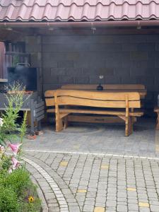 a wooden bench sitting next to a brick wall at Будинок у Олени in Pochayiv