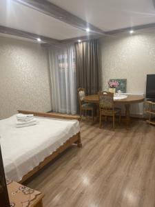 a room with two beds and a table and a dining room at Будинок у Олени in Pochayiv