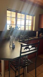 tavolo da pranzo con due sedie e tavolo con piante di Geluk Cottage a Somerset East