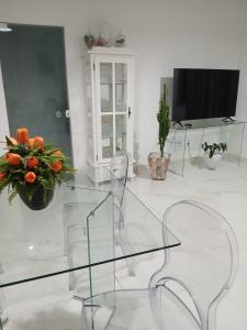 a glass table in a living room with a tv at Casa de praia em Barra do Gil in Vera Cruz de Itaparica