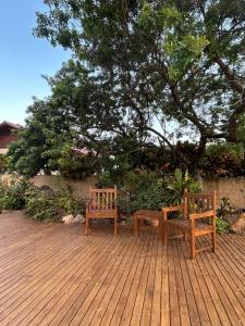 zwei Bänke auf einer Holzterrasse in der Unterkunft Casa Espaçosa com Piscina, Churrasqueira e Área verde em Sambaqui ao Lado da Praia - Floripa in Florianópolis