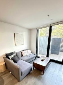 a living room with a couch and a coffee table at CBD - Pool - Sleeps 4 - Parking in Canberra