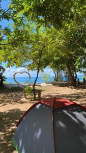 una tenda su una spiaggia con una scultura di Flor de Lótus Camping a Japaratinga