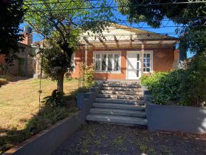 a brick house with stairs in front of it at Casa bulgara boutique in Aristóbulo del Valle