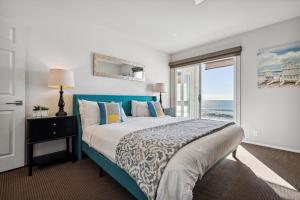 a bedroom with a bed and a window with the ocean at Seashore On The Sand in Carlsbad +45 photos