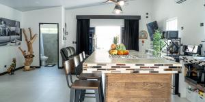 a kitchen with a counter with chairs and a table at JJ Lux Residential in Jacó