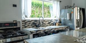 a kitchen with a sink and a stove at JJ Lux Residential in Jacó