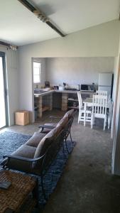 a living room with a couch and a kitchen at Springwater Cottages in Ficksburg