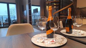 泽格雷兹Apartament Premium z jacuzzi nad Zegrzem的桌子上放着两瓶酒,带眼镜