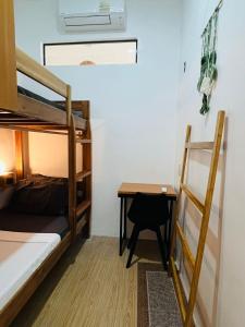 a room with two bunk beds and a desk at Pugad Hostel, El Nido in El Nido
