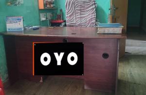 OYO 72817 Palace Inn في Jādabpur: مكتب خشبي عليه علامة ovo