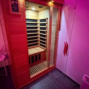 eine begehbare Dusche in einem Raum mit rosa Beleuchtung in der Unterkunft La Suite Liege in Seraing