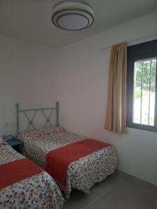 a bedroom with two beds and a window at El Antiguo Corral de Sevilla in Navalcán +15 photos